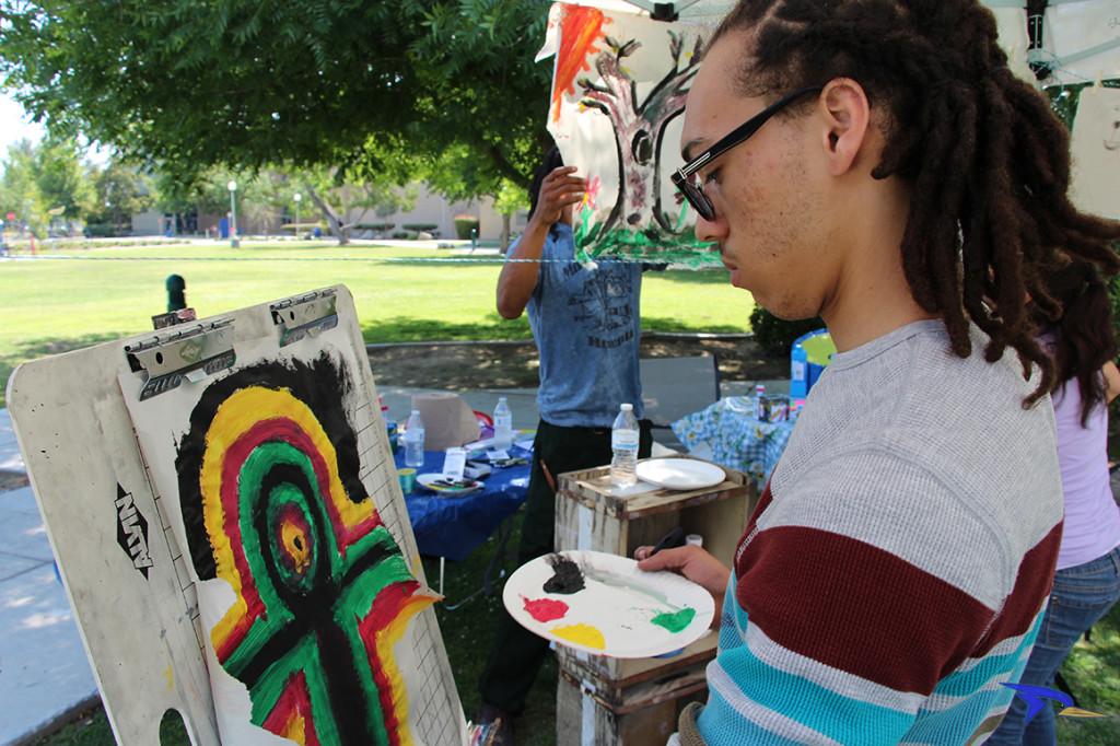 Trevante Hammonds/The Runner Sophomore philosophy major Raymone Williams makes a masterpiece at the art booth on Wednesday, May 11 outside the Student Union patio.