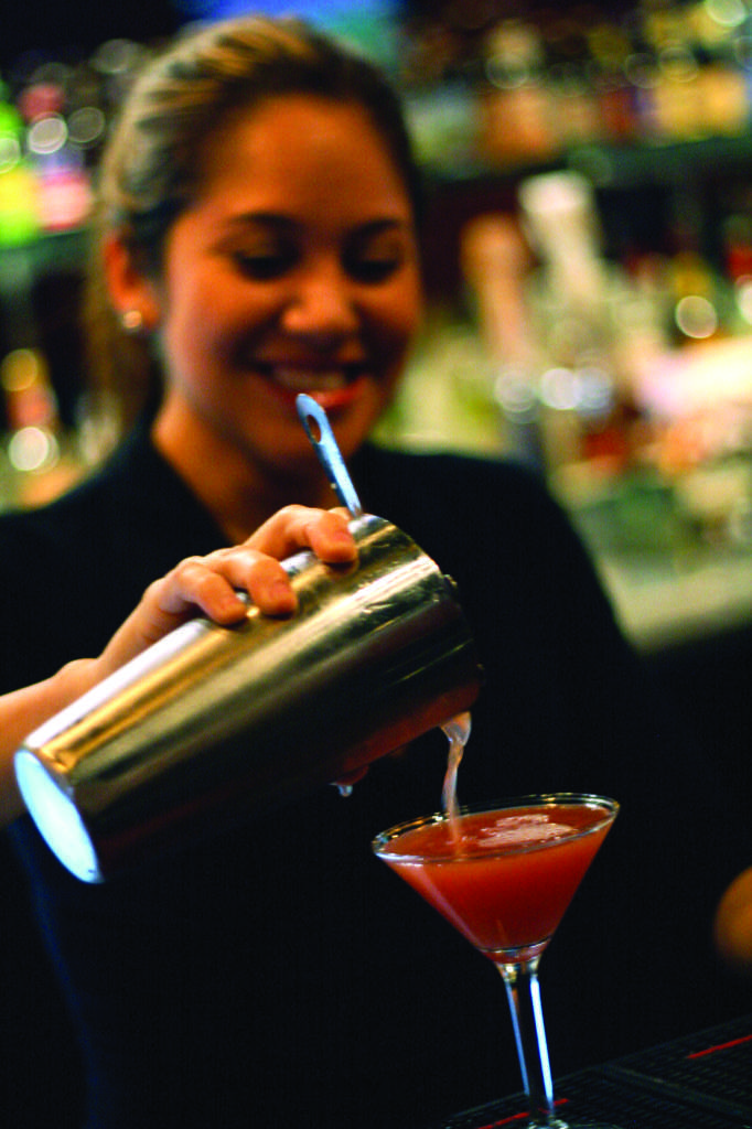 Waitress Olivia Ramos pours a drink at Just Wing It. (Michael Wafford/The Runner).