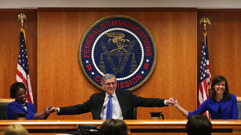 At the start of a meeting to decide the issue of net neutrality, Federal Communications Commission Chairman Tom Wheeler (center) holds hands with FCC Commissioners Mignon Clyburn (left) and Jessica Rosenworcel at the FCC headquarters Thursday.
Mark Wilson/Getty Images