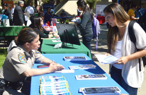 Eva Carabajal, California Highway Patrol Officer, speaks with Gladis Herrera, Criminal Justice major, about the difficulty of training at the CSUB Career Fair on April 15.