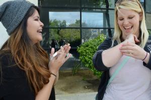 Cristal Mondragon, junior, and Julie Estep, Kern High School Employee, share a laugh as they marvel over Estep's flash tattoo on April 7 at the CSUB Fashion Club fundraiser.
