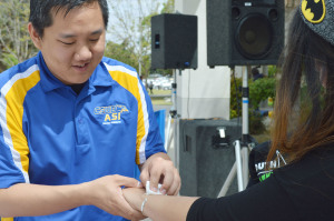 Mike Kwon, ASI and CSUB Fashion Club member, gives Cristal Mondragon, junior, a flash tattoo at the CSUB Fashion Club fundraiser on April 7.