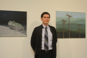 Derek Ryan Posing for the camera with his paintings “ Stars” (Left) and “Hillside” (Right) at the opening of Nexus senior art exhibition on Thursday, May 14 at Todd Madigan Gallery