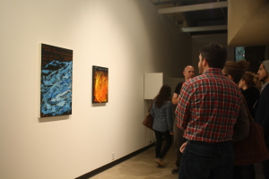 Guest admiring Donald Myers “Game of Life” (Left) and “Hello World” (Right) at the opening of Nexus senior art exhibition on Thursday, May 14 at Todd Madigan Gallery