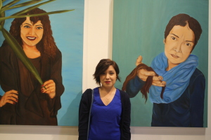Perla V. Diaz taking a photo with her paintings "Weathering life's strom" during the opening of Nexus senior art exhibition on Thursday, May 14 at Todd Madigan Gallery
