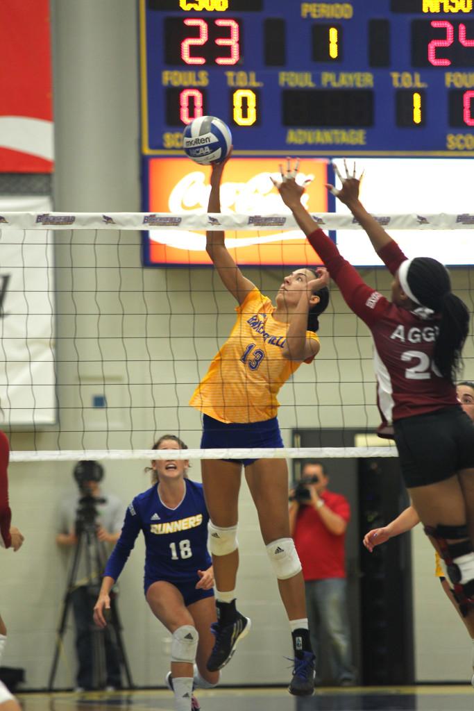 Senior middle blocker Sydney Haynes spikes the ball past the New Mexico State defense.
Photo by AJ Alvarado/The Runner