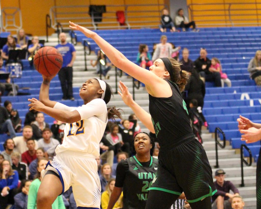 CSUB guard Alexxus Gilbert  attempts a layup against Utah Valley's senior center Sam Loggins on Saturday in the Icardo Center. 
Photo by Alejandra Flores/The Runner