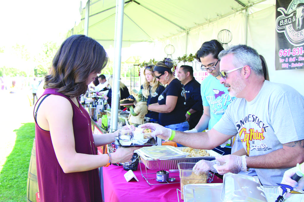 Lucille’s Smokehouse Bar-B-Que serves a portion to an attendees.
