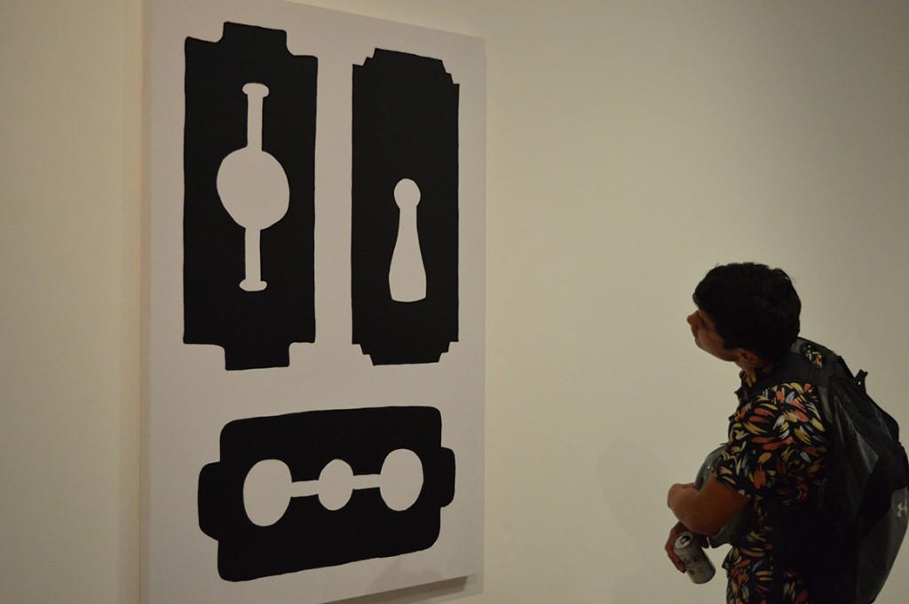 Nicholas Reyes gazes upon the artwork by Kate Costello “Razor Drawing” in a different perspective. Photo by Trevante Hammonds/The Runner