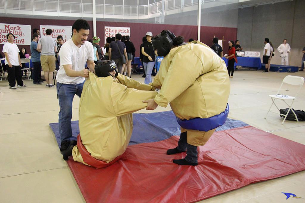 Karina Diaz/The Runner High school volunteer Maggie Frost getting help to get up at the Japanese Night Festival after some sumo fighting on Friday, May 20 at the Student Recreation Center.