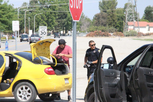 Officer Freddie Reyes searches a Dodge Neon for illegal substances on May 10. Photo By Chris Mateo/The Runner 