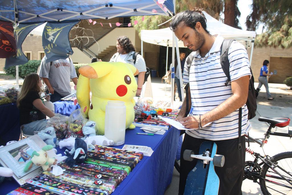 Computer science major Cesar Loya signing up for campus gamers at the club fair on Friday, August 26.
By Karina Diaz/The Runner 
