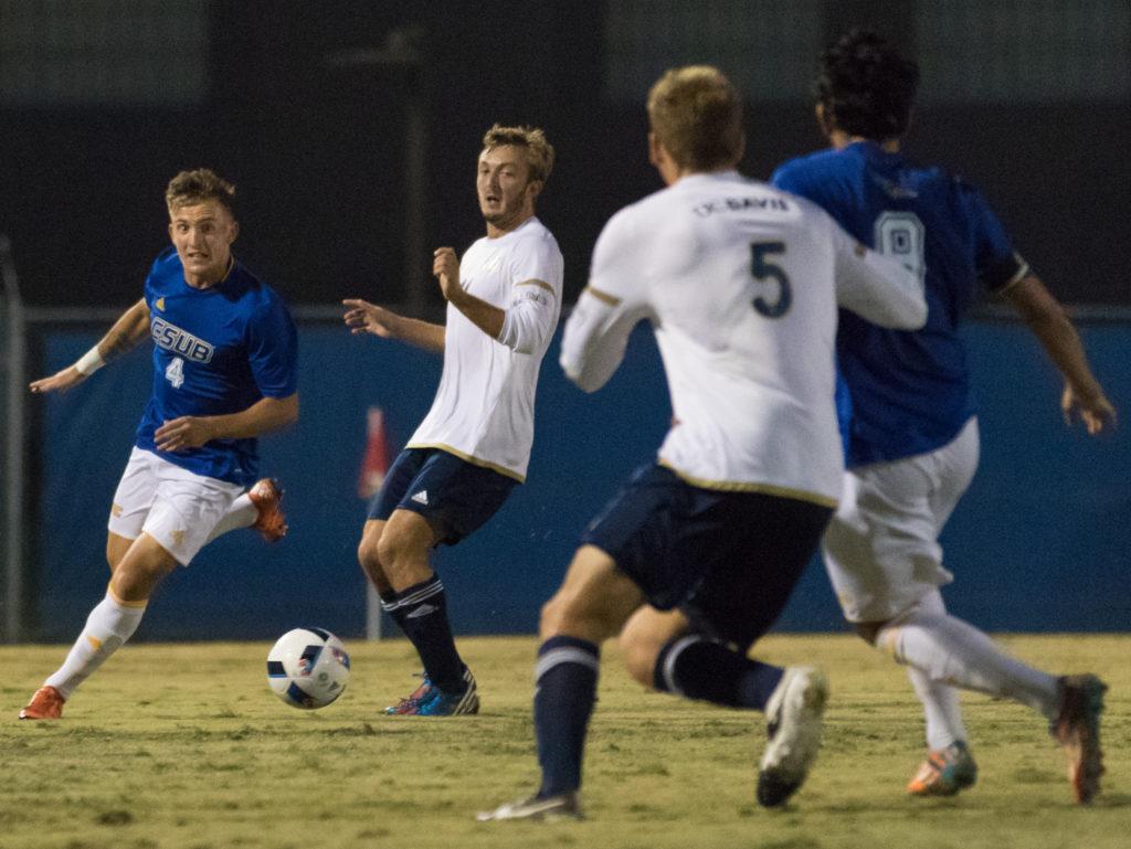 CSUB’s senior defender Jamie Carey-Morrell dribbles against UC Davis’ Matt Baringer as Chase Rhode and CSUB’s Hugo Vinales look on during the first half of Thursday’s game at CSU Bakersfield.
