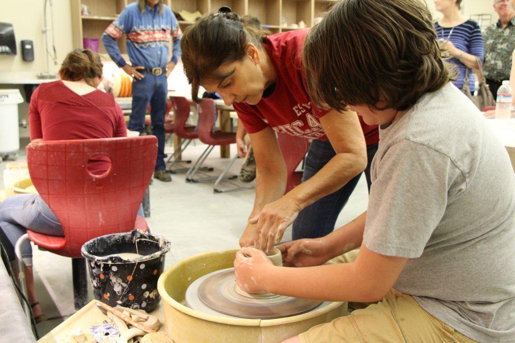 Dale Wolf, art studio major teaching Dylan Scully, 11 how to throw pottery during the Taste of the Arts event on Sunday.
Alejandra Flores/ The Runner