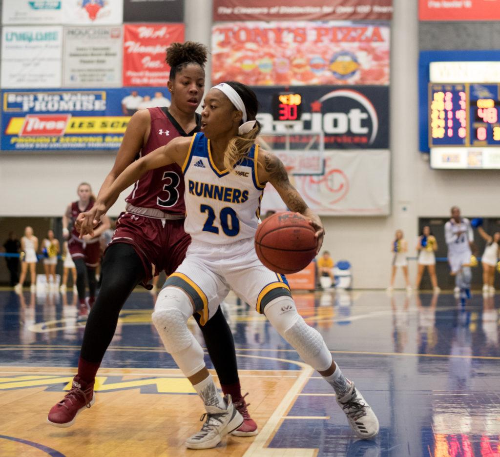 Redshirt-junior guard Jazmine Johnson dribbles past a New Mexico State defender during a game on Feb. 10 at the Icardo Center.
Photo by Simer Khurana/ The Runner