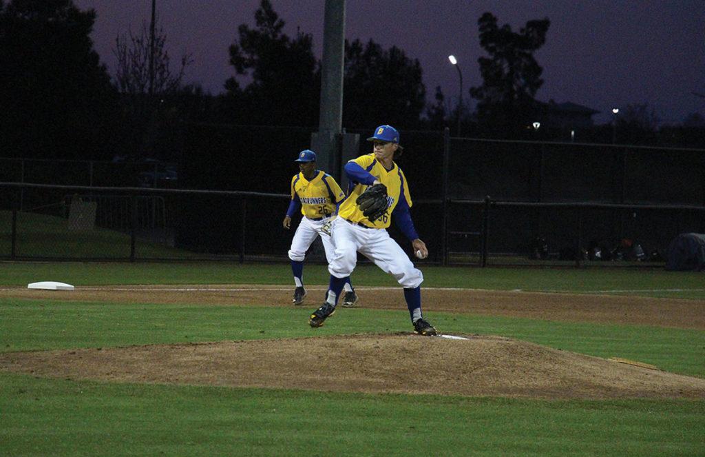 CSUB’s starting pitcher, #36 Kyle King makes a pitch as third baseman, #26 Daniel Carrizosa looks on.
