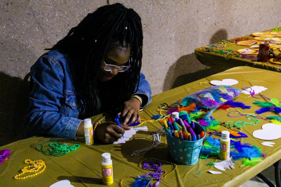 Psychology major Ellen Ijebor runs the crafts table, inviting guests to create their own masks during the MasQUEERade Ball in the Stockdale Room on Friday, March 29. Leo Garcia/The Runner