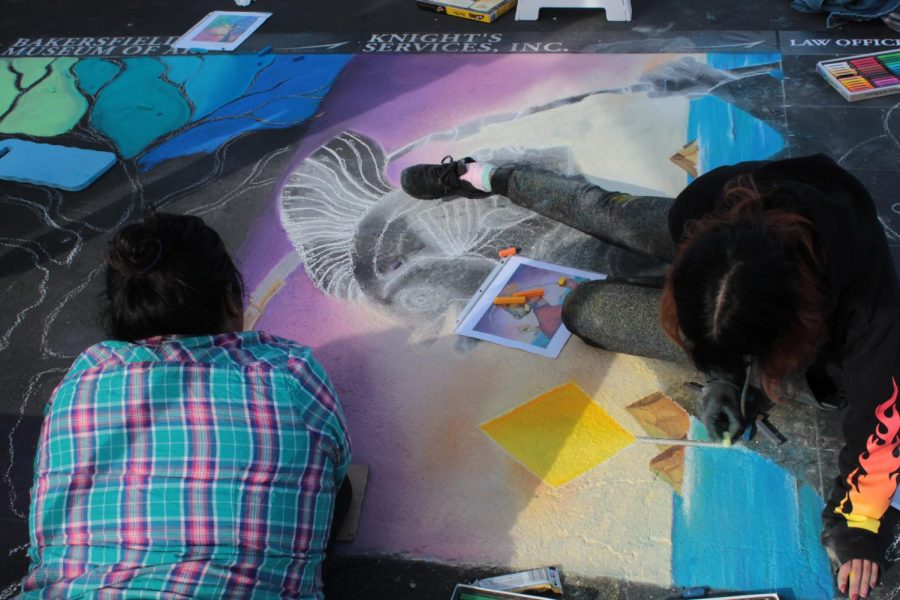 Artist Ana Reyes and and Kaylee Carlson work on their piece on Day 1 of Via Arté at the Market Place. 