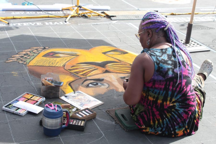 Artist Lori Antoinette works on her piece on Day 1 of Via Arté at the Market Place. 