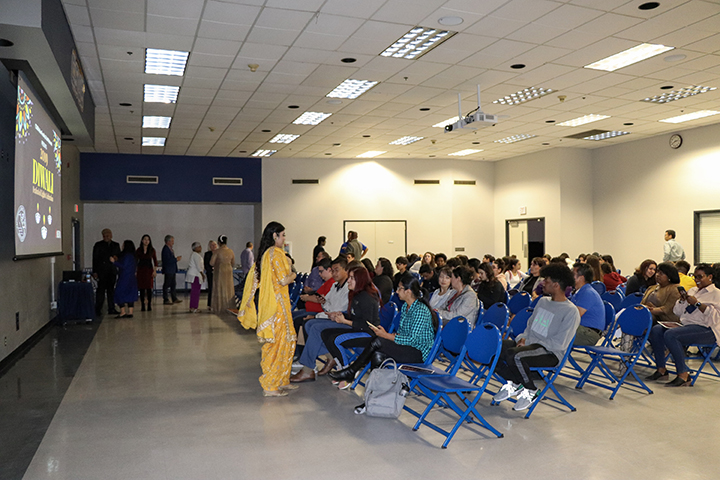Henna Singh (in yellow) stands in front of the crowd ready to begin the Diwali festival. Singh was the emcee for the event.  