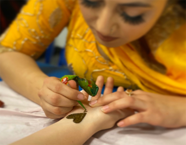 Henna Singh is pictured applying henna tattoo on a student at the Diwali Festival. Henna is a paste made from leaves of Lawsonia inermi. 