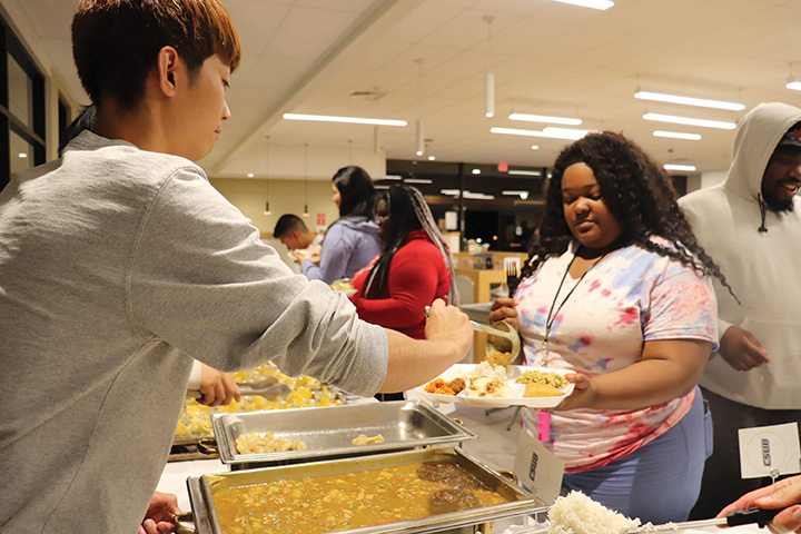 On Nov. 20, 2019, international student, Hikaru Sumie, is seen serving a Japanese cuisine to students at the Runner Café during the International Food and Culture Show.