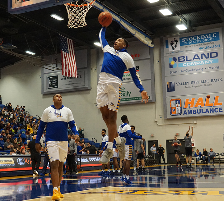 Senior forward Justin Edler Davis goes for a slam dunk during warm ups on Saturday Jan. 25that the Icardo Center
