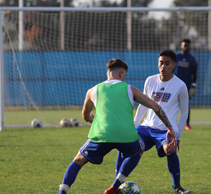 Sophomore midfielder Carlos Armendariz practices his defense skills against one of his teammates during their training practice on Thursday Jan. 30th on the main soccer at CSUB. 