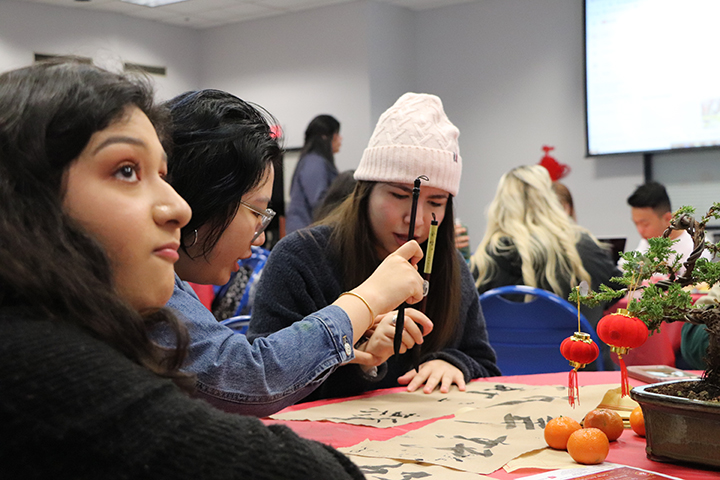 CSUB Art majors Vanessa Ramirez (left), Yi Sing (center), Lorena Cazeras (right), learning calligraphy at the Lunar New Year festival on Jan. 30 at the Student Union.