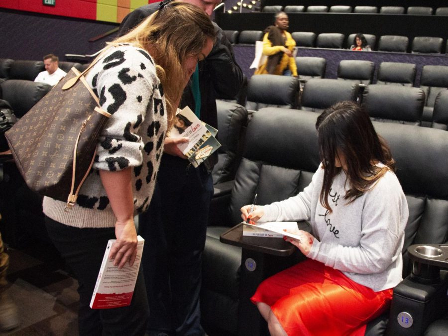 Rebecca Bender signs an autograph on her book, "In Pursuit for Love" for an attendee at her event.