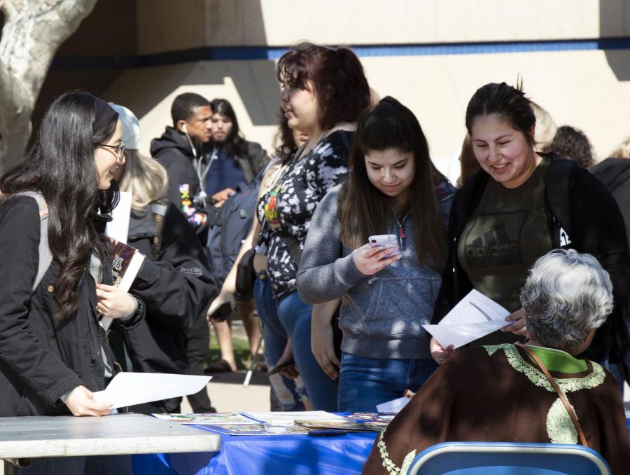 Students gather at the Hinduism resource table to talk and speak with representatives at the Interfaith Resource Fair on Feb. 19.