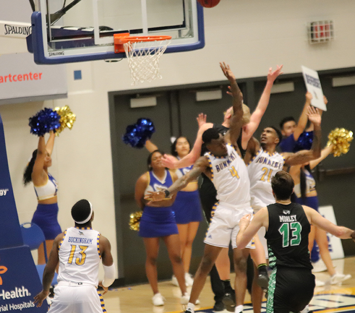 Junior Taze Moore and Junior Greg Lee try to block opponent from making the basket