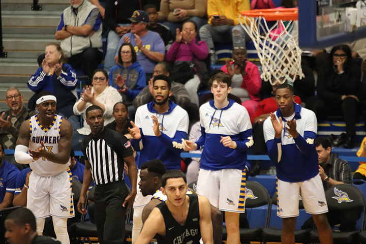 Some of the men's basketball players cheering their teammates on against Chicago State. 