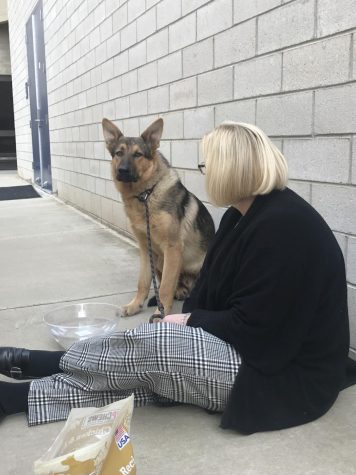 Lori Blodorn sitting with "Champ" the campus German Shepherd