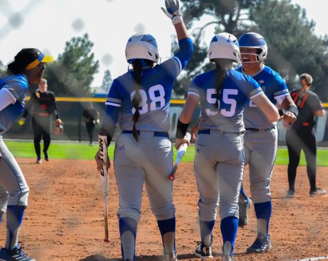 Softball players celebrating and high diving. 