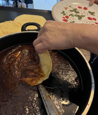 Dipping the tortillas one by one into the mole sauce