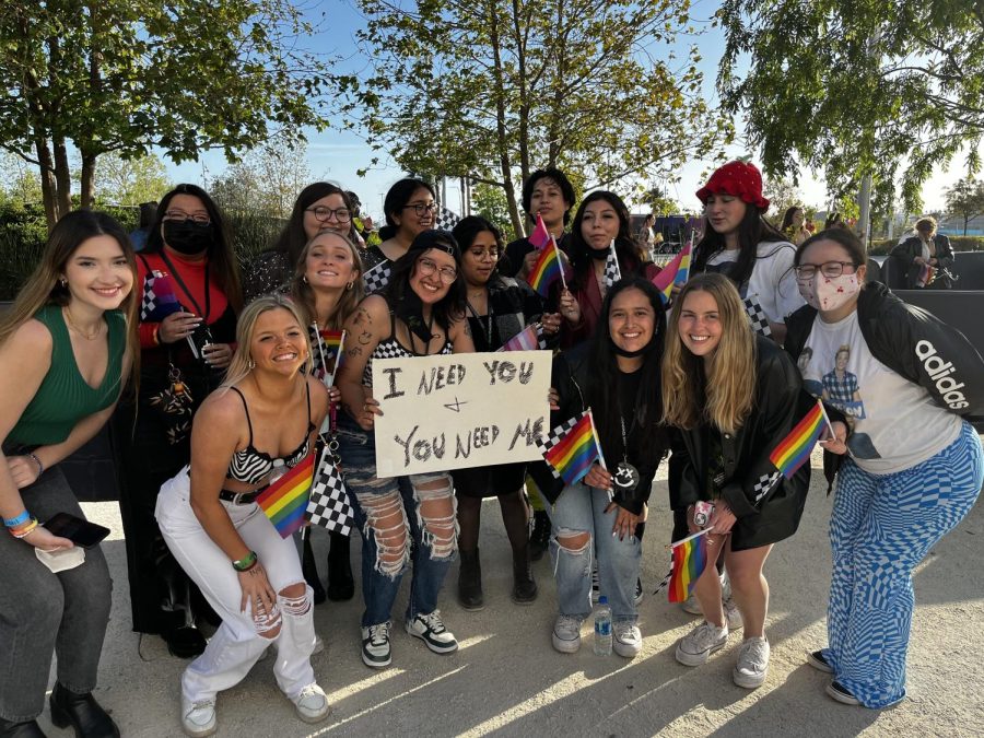 Kiara and her newly made friends posing with a sign they made to grab Louis Tomlinson's attention.