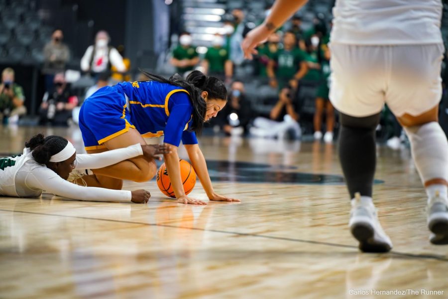 CSUB's TATYANNA CLAYBURNE attempts to maintain possession as Hawaii turns up the defensive pressure.
