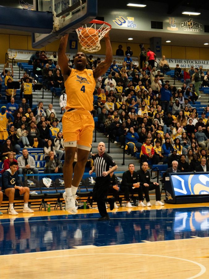 Forward guard Antavion Collum scoring a slam dunk after rebounding the ball from UC Davis. Photo by Ranara Lim/The Runner.