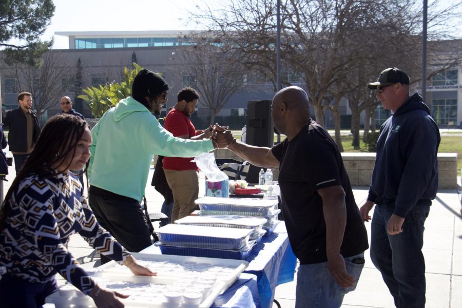 Jovon Dangerfield media personality from 109.3, greeting his friend Leon Anthony the owner of Nov's soul food at the Black History Kick off event 