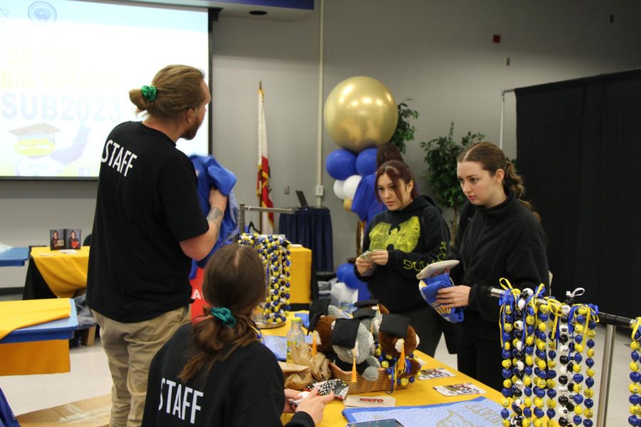 Madison Herron and Eileen Chavez, psychology majors, look at one of the booths at CSUB 2023 grad fest.