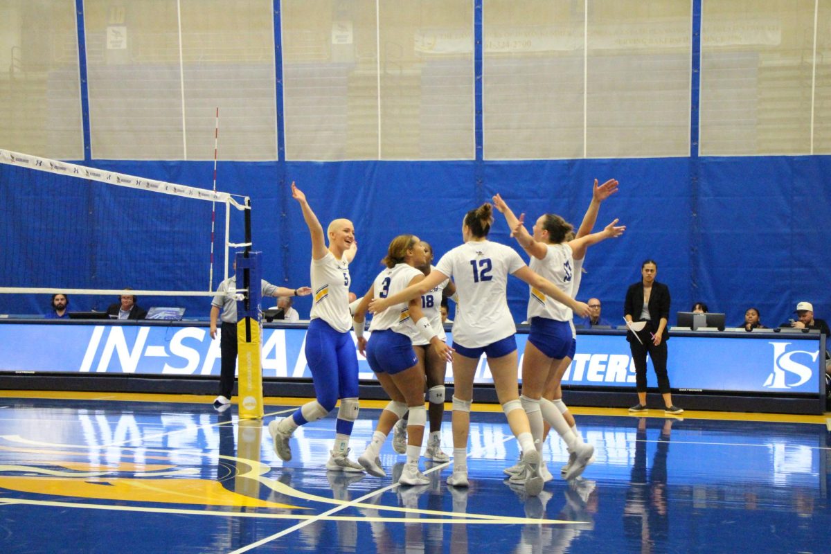 California State University, Bakersfield's women's volleyball team celebrated on the court after scoring points. 