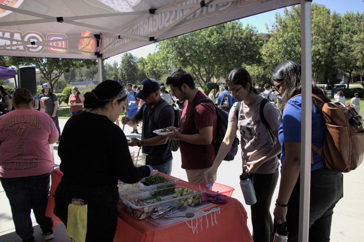  Students and faculty serve themselves, asada or el pastor, tacos at ASI Runner Hour.  