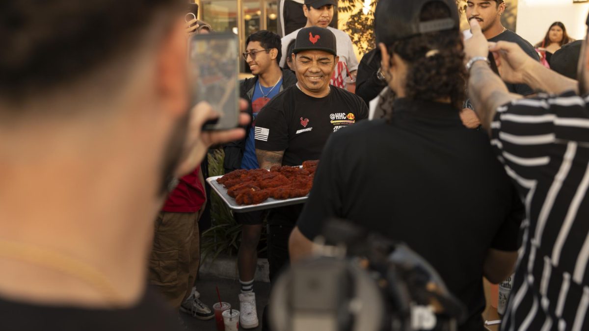 An employee of Houston's Hot Chicken brings out Houston’s Hot Chicken's hottest tenders and shows
them off to the spectators.