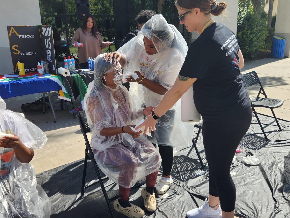 ASA student helping another student clean up after being pied.