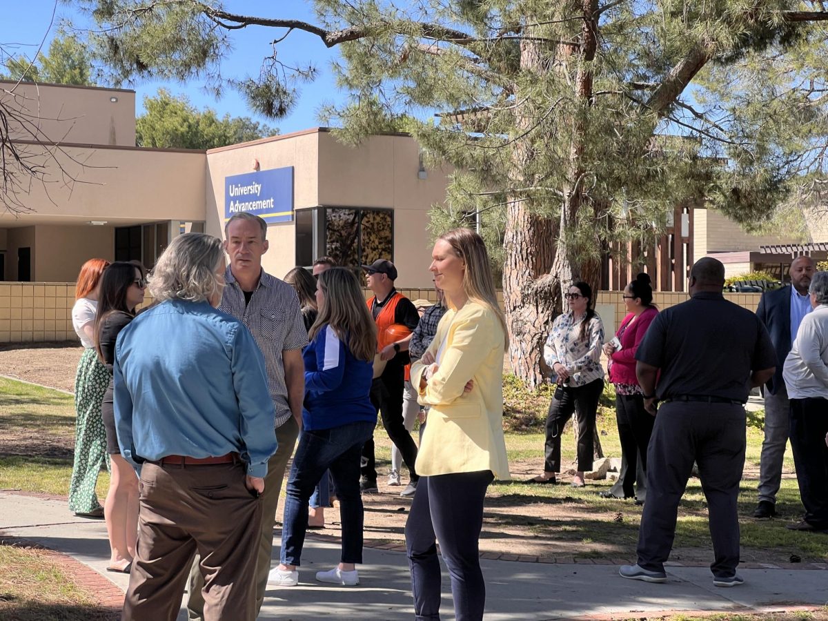 Faculty, students, and staff outside in front of University Advancement on April 9, waiting for the safety drill to end. 