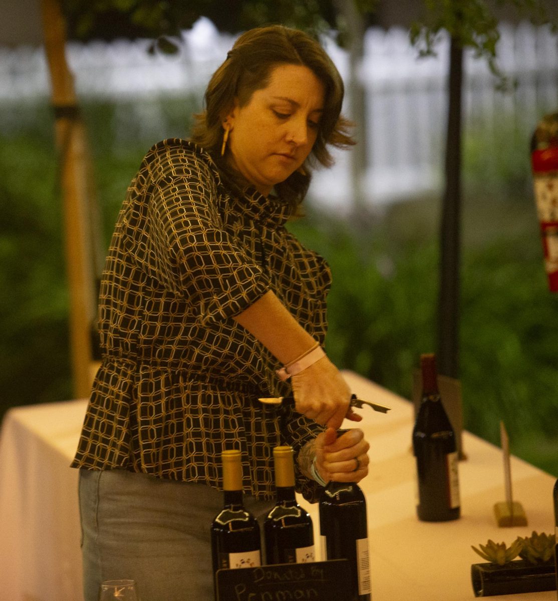 Dr. Aubrey Kemp, Mathematics Professor, serves up wine at the Sip and Scholarship event on Friday March 31. 