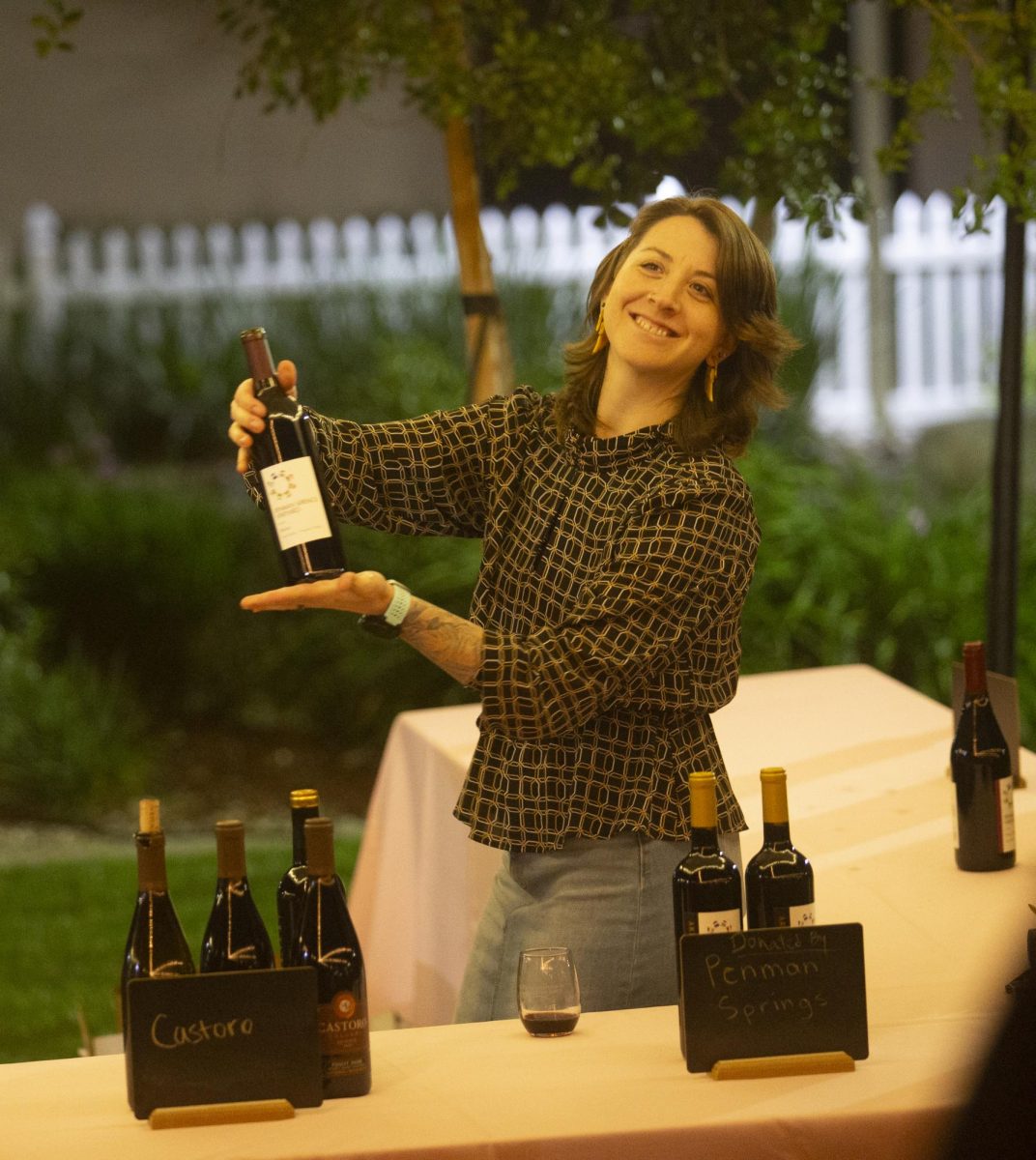 Dr. Aubrey Kemp, Mathematics Professor, serves up wine at the Sip and Scholarship event on Friday March 31. 