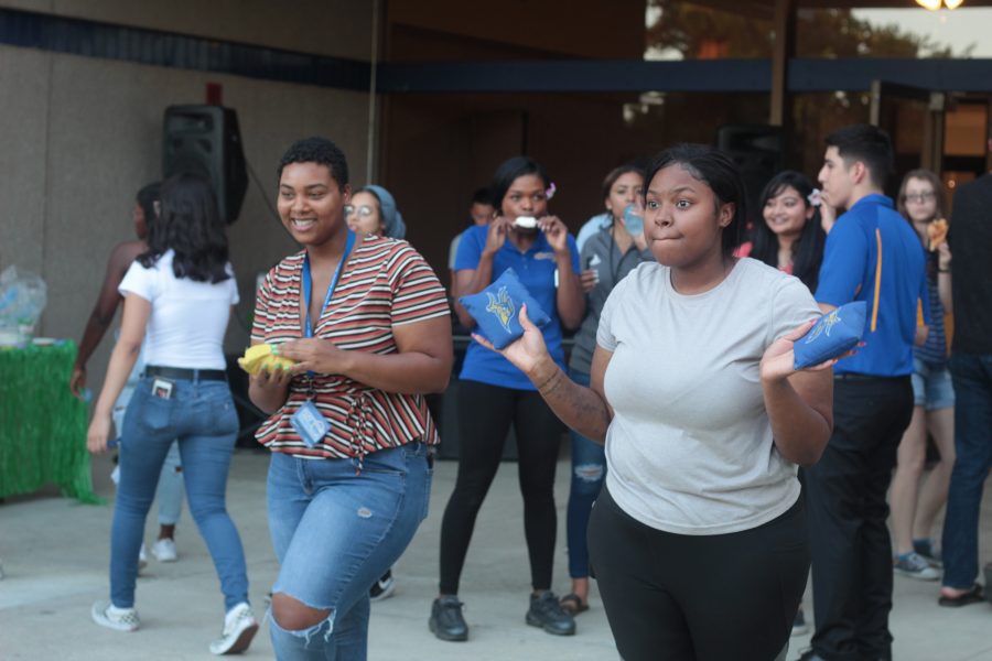 Erykah Jenkins, a Junior Human Biology Major and Dejah Archer, a Junior CAFS major enjoy a game of bean bag toss at the Runner Luau.